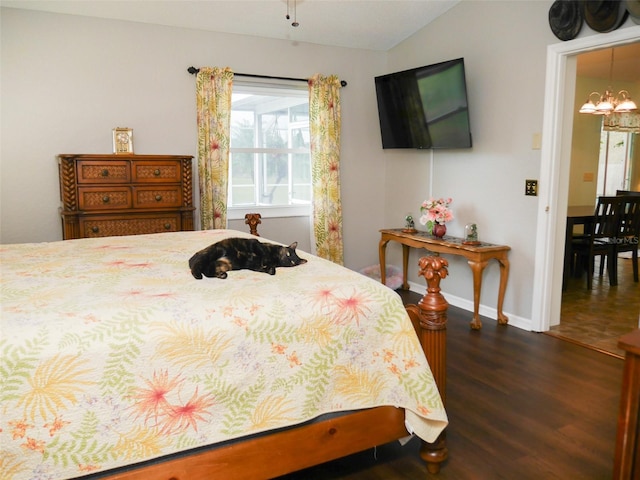 bedroom with lofted ceiling, dark wood-style floors, baseboards, and a notable chandelier