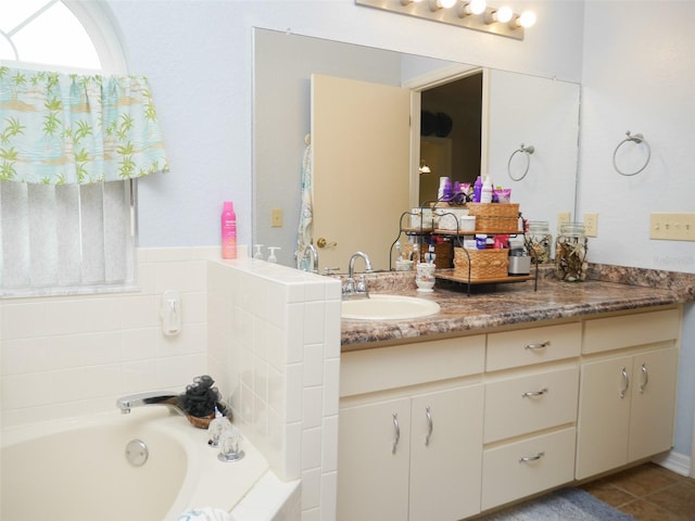 full bathroom featuring a garden tub, vanity, and tile patterned floors