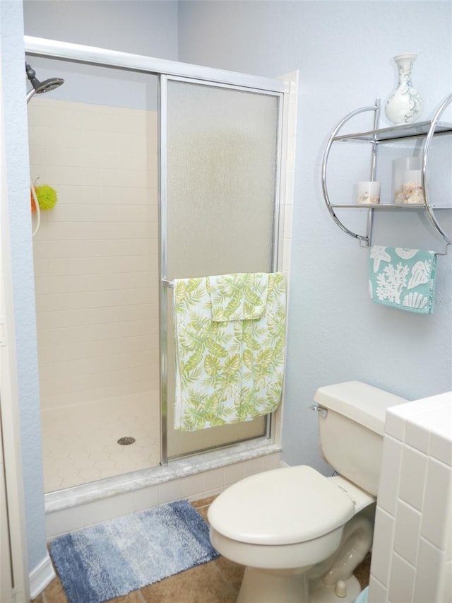 bathroom featuring a stall shower and toilet