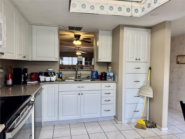 kitchen with stone counters, white cabinetry, black dishwasher, sink, and electric range