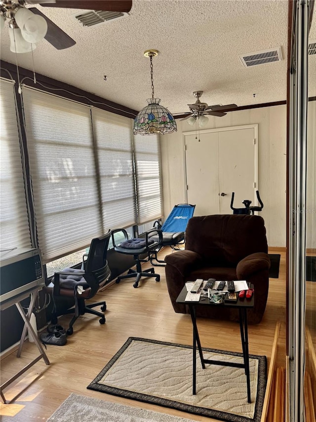 office space featuring ceiling fan, wood-type flooring, and a textured ceiling