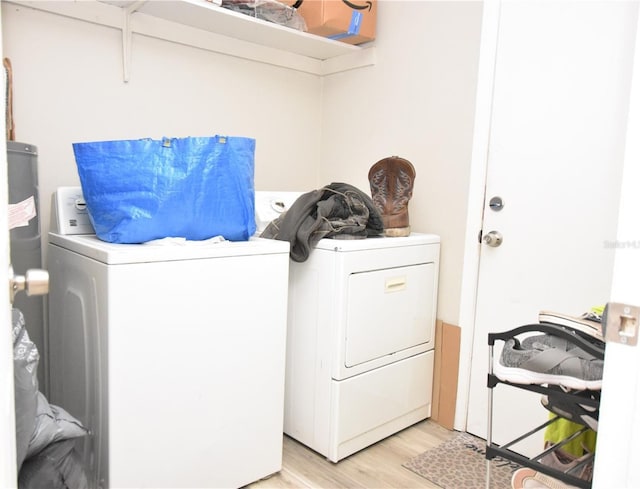 laundry area with laundry area, washing machine and dryer, and light wood finished floors