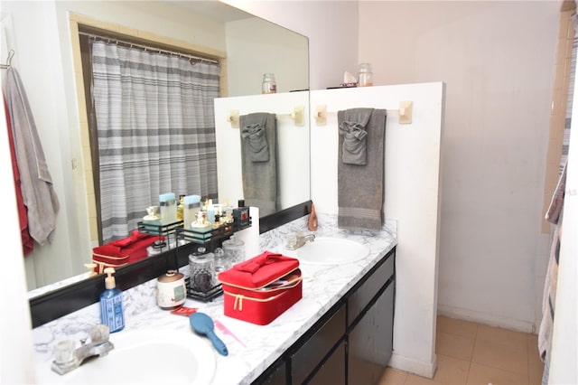 full bathroom with tile patterned flooring, a sink, baseboards, and double vanity