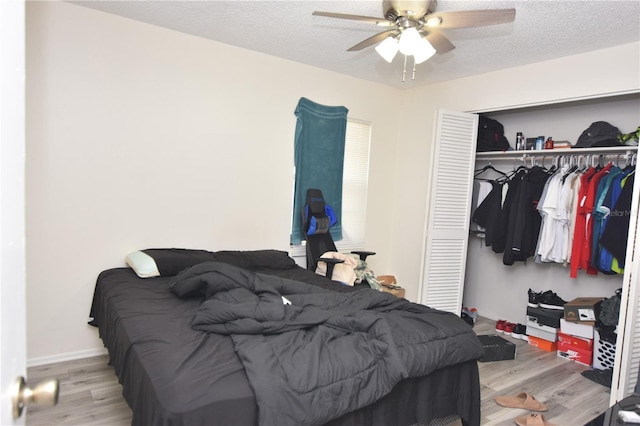 bedroom featuring light wood-style floors, a closet, ceiling fan, and a textured ceiling