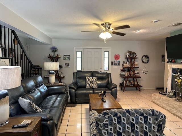 tiled living room with ceiling fan and a textured ceiling