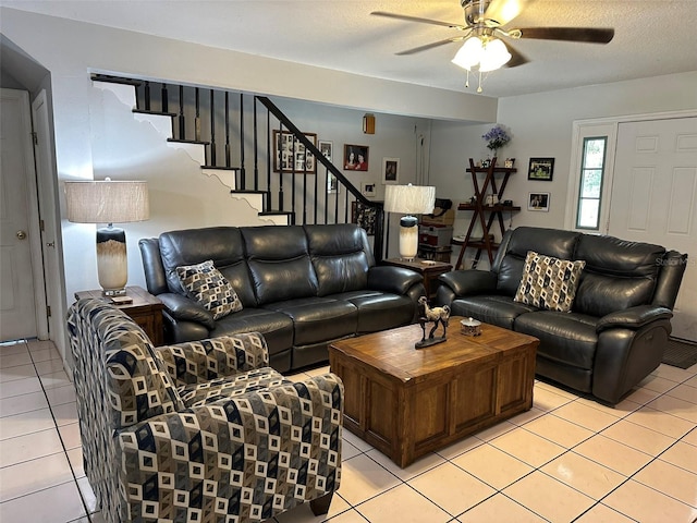 living room featuring light tile patterned flooring, ceiling fan, and a textured ceiling