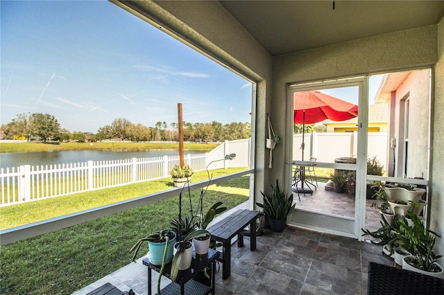 sunroom / solarium featuring a water view