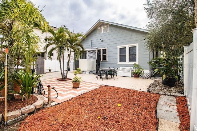 rear view of house featuring a storage shed and a patio area