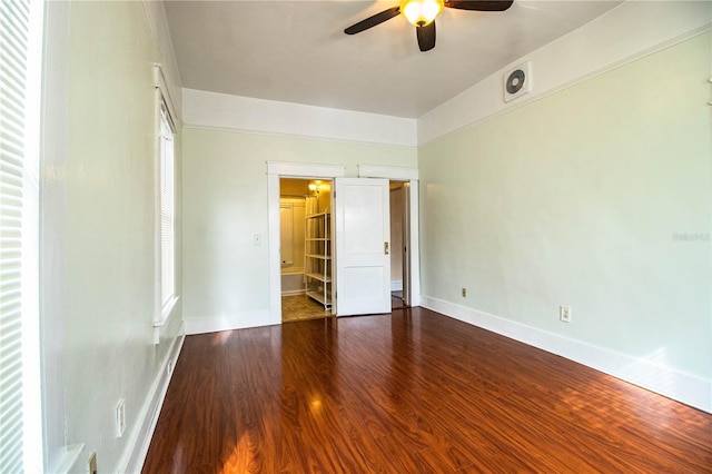 unfurnished bedroom featuring ceiling fan, wood-type flooring, and connected bathroom