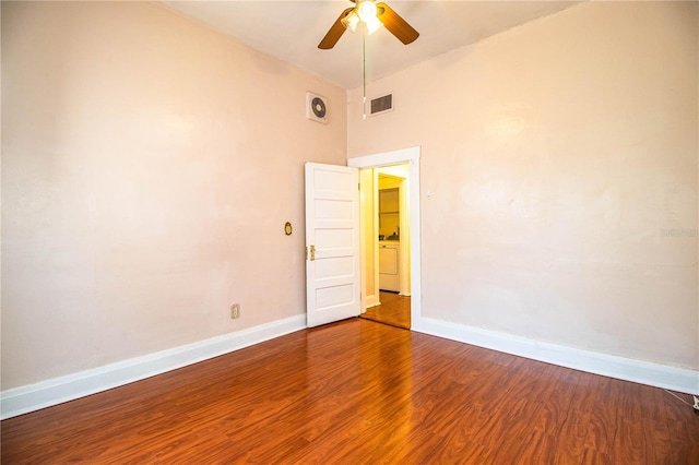 empty room with hardwood / wood-style floors, washer / clothes dryer, and ceiling fan