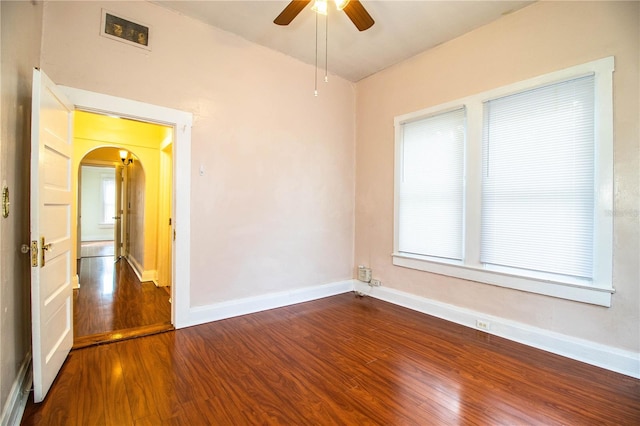 spare room featuring a healthy amount of sunlight, dark hardwood / wood-style floors, and ceiling fan