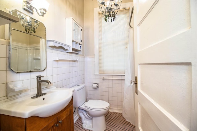 bathroom with vanity, tile walls, and toilet