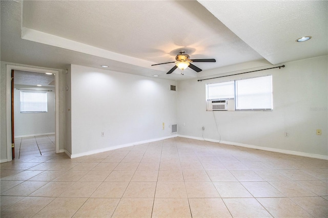 empty room with cooling unit, ceiling fan, a textured ceiling, and light tile patterned floors