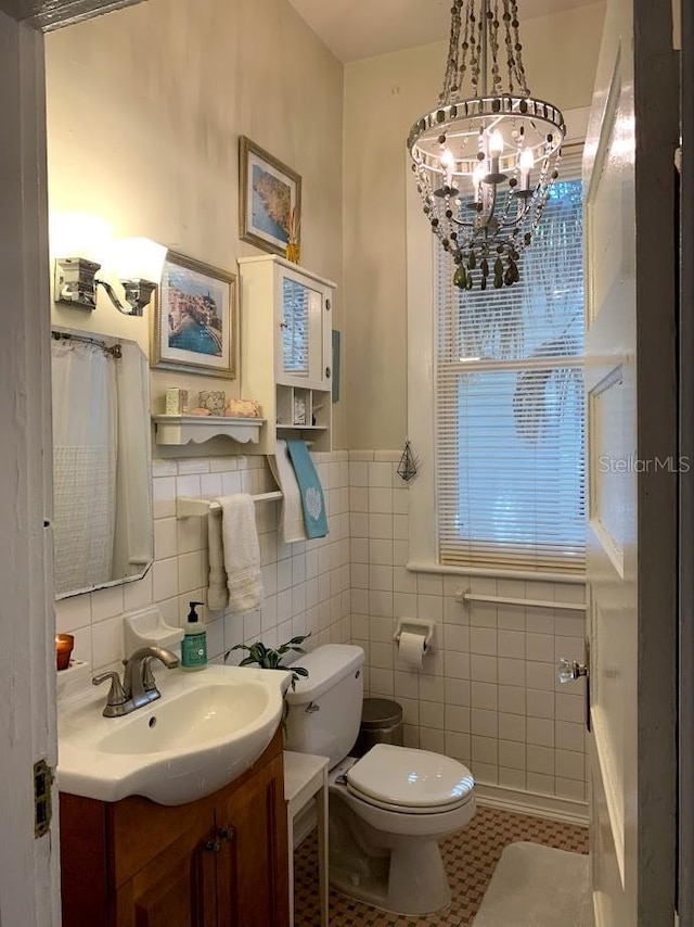 1919 W N A St, Tampa, FL 33606 - bathroom featuring a notable chandelier, tile walls, toilet, vanity, and a wainscoted wall