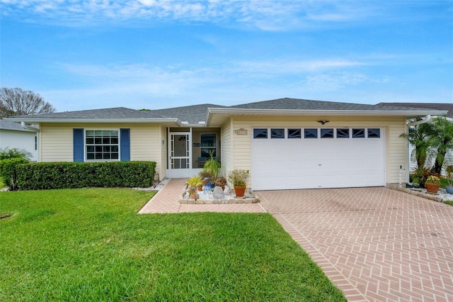 single story home with a garage, decorative driveway, and a front lawn