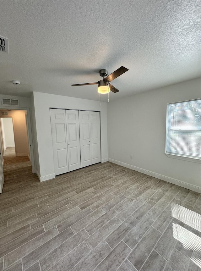 unfurnished bedroom featuring a closet, light wood-type flooring, visible vents, and baseboards