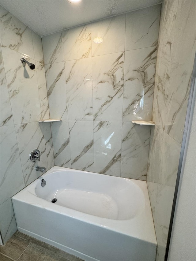 full bath with shower / tub combination and a textured ceiling