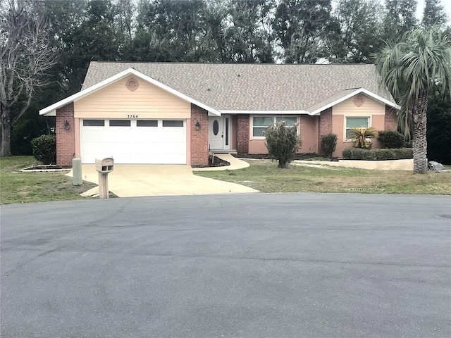 ranch-style home with a garage, brick siding, driveway, and a front lawn