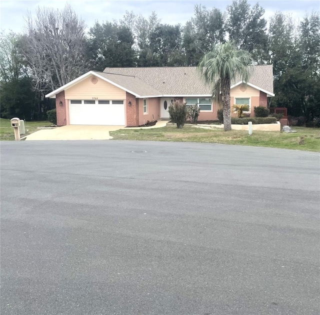 ranch-style house featuring driveway, brick siding, and an attached garage