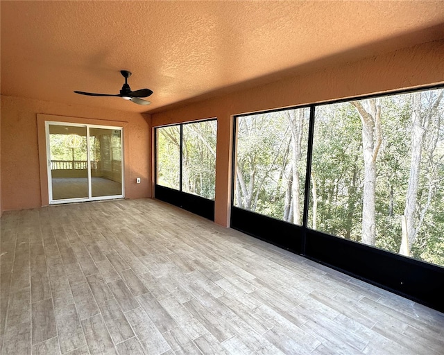 unfurnished sunroom featuring ceiling fan