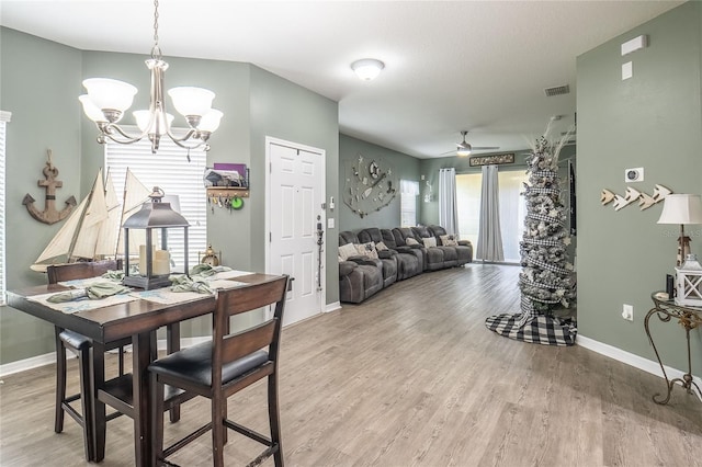 dining area featuring ceiling fan with notable chandelier and hardwood / wood-style flooring