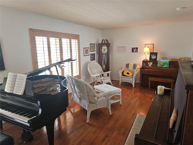 sitting room featuring a textured ceiling and dark hardwood / wood-style flooring