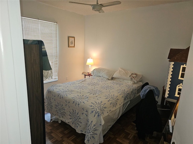 bedroom with ceiling fan and dark parquet floors