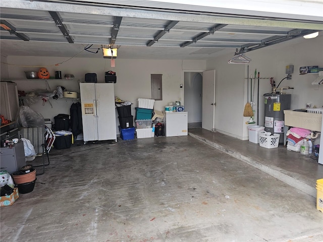 garage with water heater, sink, white fridge with ice dispenser, electric panel, and a garage door opener