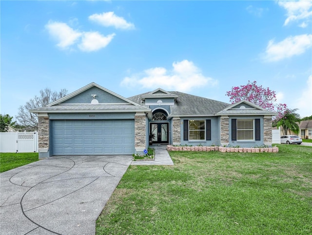 ranch-style home with a front lawn, stone siding, and an attached garage