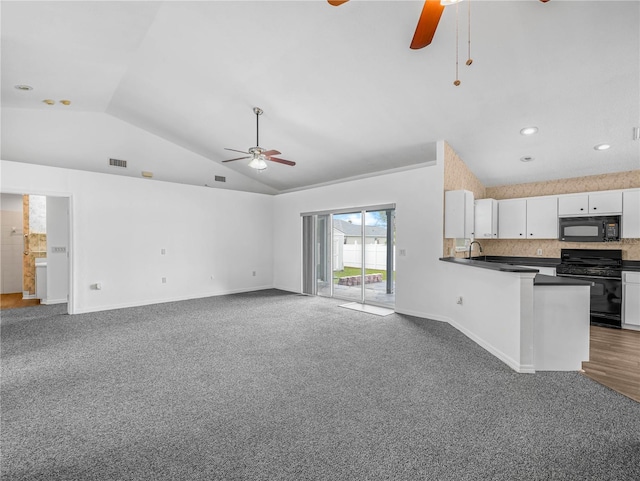 interior space with baseboards, lofted ceiling, ceiling fan, dark colored carpet, and a sink