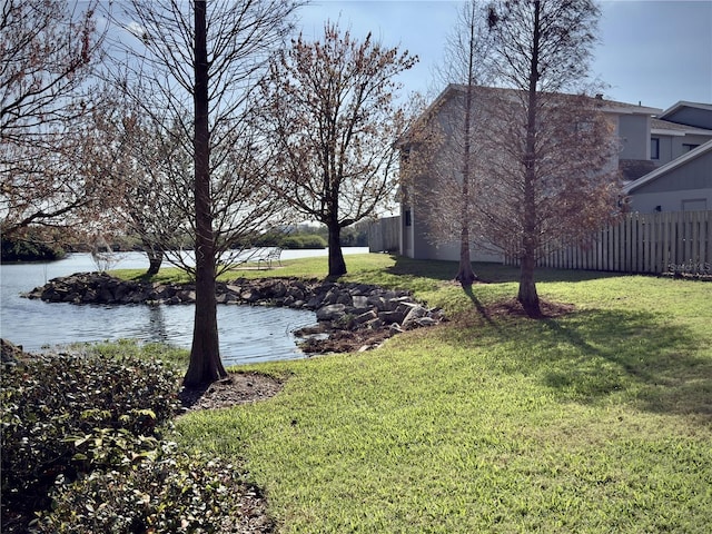 view of yard with a water view and fence