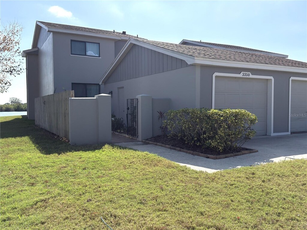 view of front facade with a garage, a front yard, and stucco siding