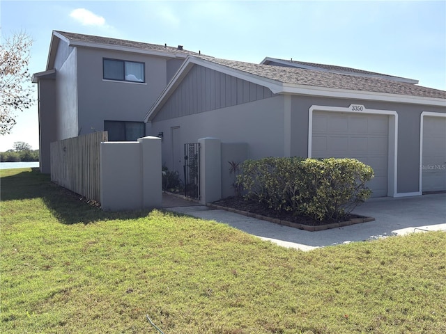 view of front facade with a garage, a front yard, and stucco siding