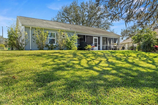 back of property featuring a yard and a sunroom