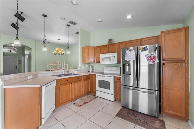 kitchen featuring arched walkways, light countertops, visible vents, a sink, and white appliances