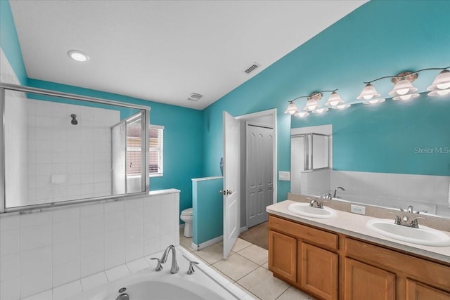 bathroom with a garden tub, visible vents, a sink, and toilet