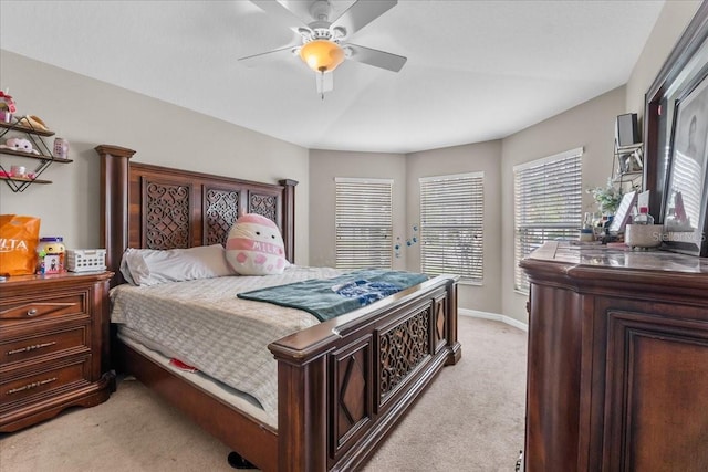 bedroom with a ceiling fan, light carpet, and baseboards