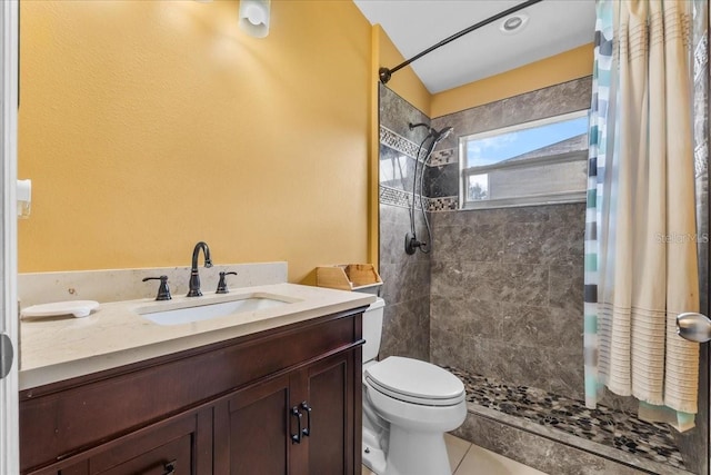 full bath with tiled shower, vanity, toilet, and tile patterned floors