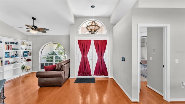 entryway featuring ceiling fan with notable chandelier and hardwood / wood-style floors