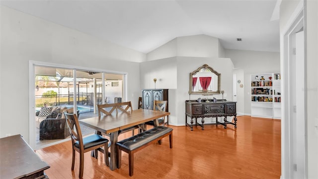 dining room featuring hardwood / wood-style flooring and high vaulted ceiling