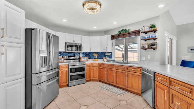 kitchen with sink, decorative backsplash, light tile patterned floors, kitchen peninsula, and stainless steel appliances