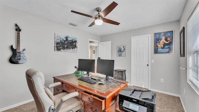 carpeted home office featuring ceiling fan