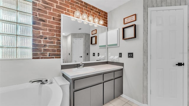 bathroom with tile patterned flooring, a bathing tub, brick wall, and vanity