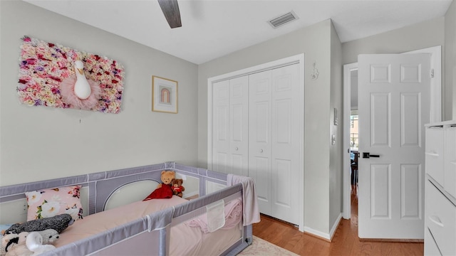 bedroom with light hardwood / wood-style flooring, a closet, and ceiling fan