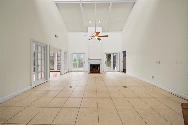 unfurnished living room featuring ceiling fan, high vaulted ceiling, a fireplace, light tile patterned flooring, and beamed ceiling