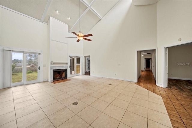 unfurnished living room with ceiling fan, lofted ceiling, light tile patterned floors, and a fireplace