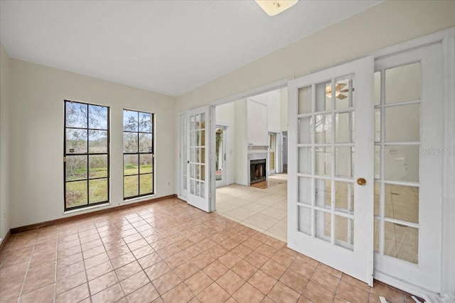 tiled empty room featuring french doors