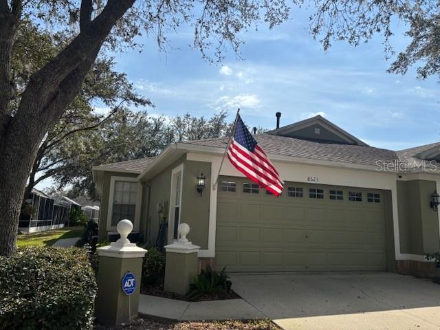 8623 Snowy Owl Way, Tampa, FL 33647 - single story home with an attached garage, a shingled roof, driveway, and stucco siding