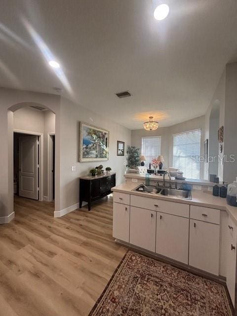 8623 Snowy Owl Way, Tampa, FL 33647 - kitchen featuring a sink, visible vents, white cabinets, and arched walkways