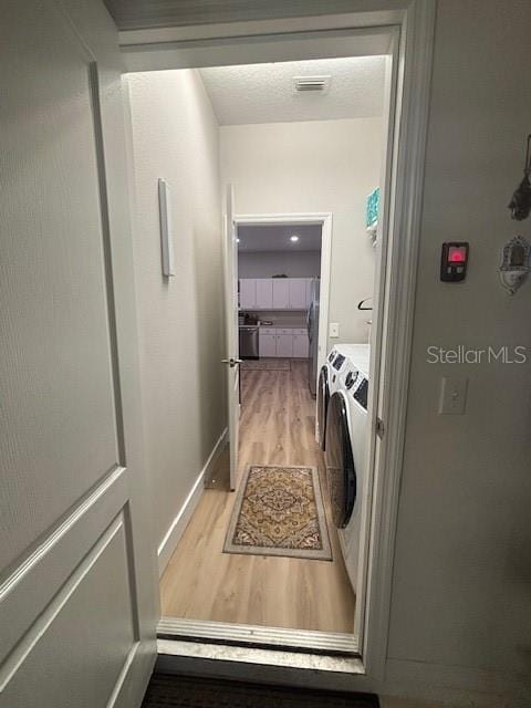 8623 Snowy Owl Way, Tampa, FL 33647 - washroom with visible vents, baseboards, laundry area, light wood finished floors, and washing machine and clothes dryer